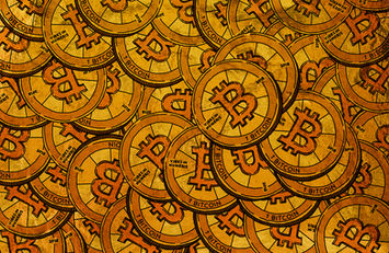 Illustrative pile of physical tokens bearing the Bitcoin symbol.