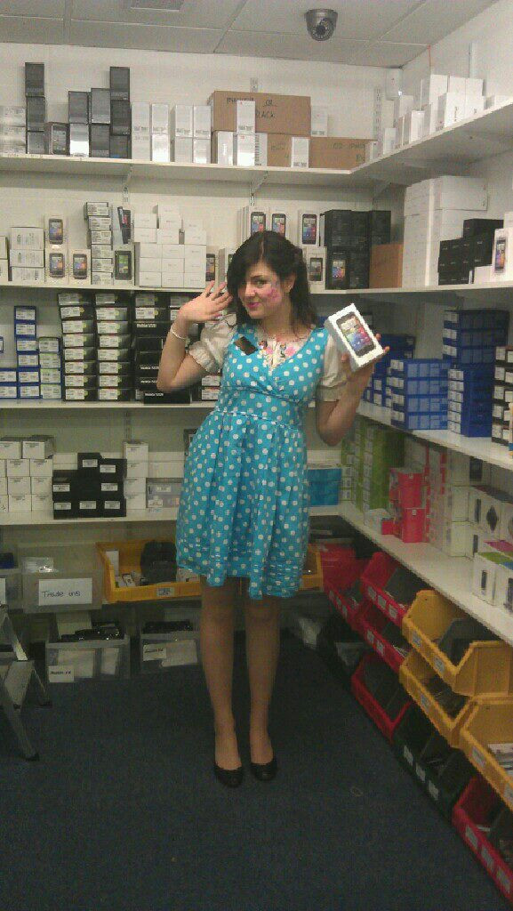 Hannah holding a phone in a staff room