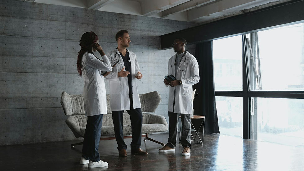 Three doctors in a modern office discussing medical matters in natural light.