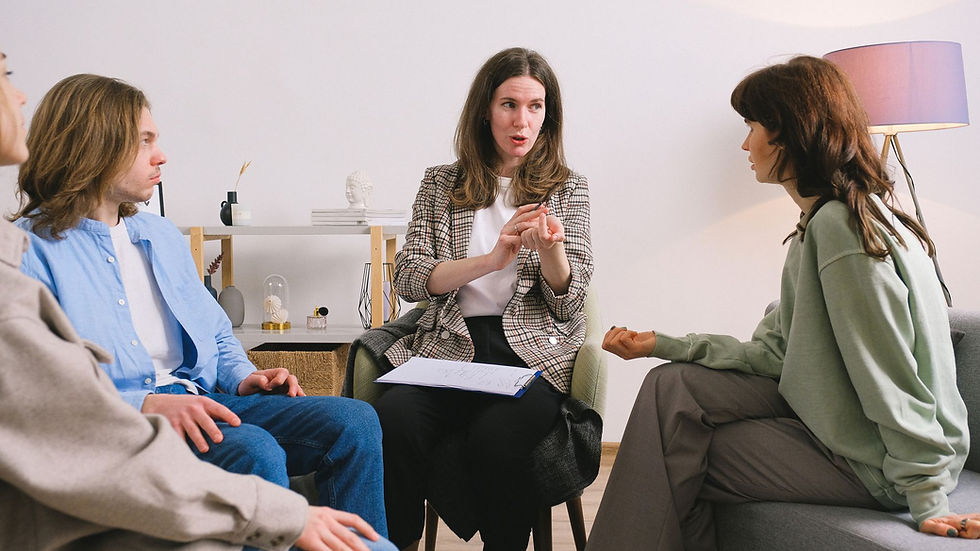 Female therapist during group session talking to female patients gathering in light cozy office