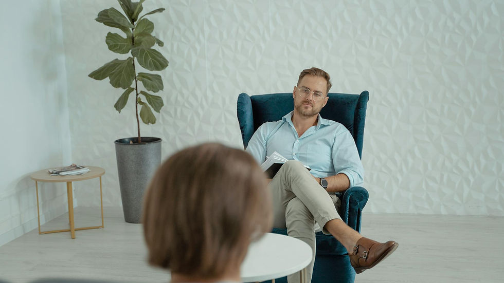 A counseling session with a man sitting in a comfortable chair indoors.