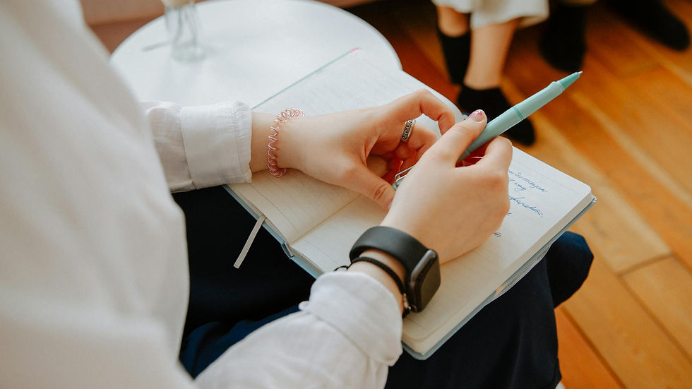 Close-up of a person taking notes during a therapy session, highlighting mental health focus.
