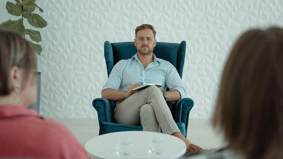 Therapist conducting a session with clients in a modern office setting. Focused professional atmosphere.