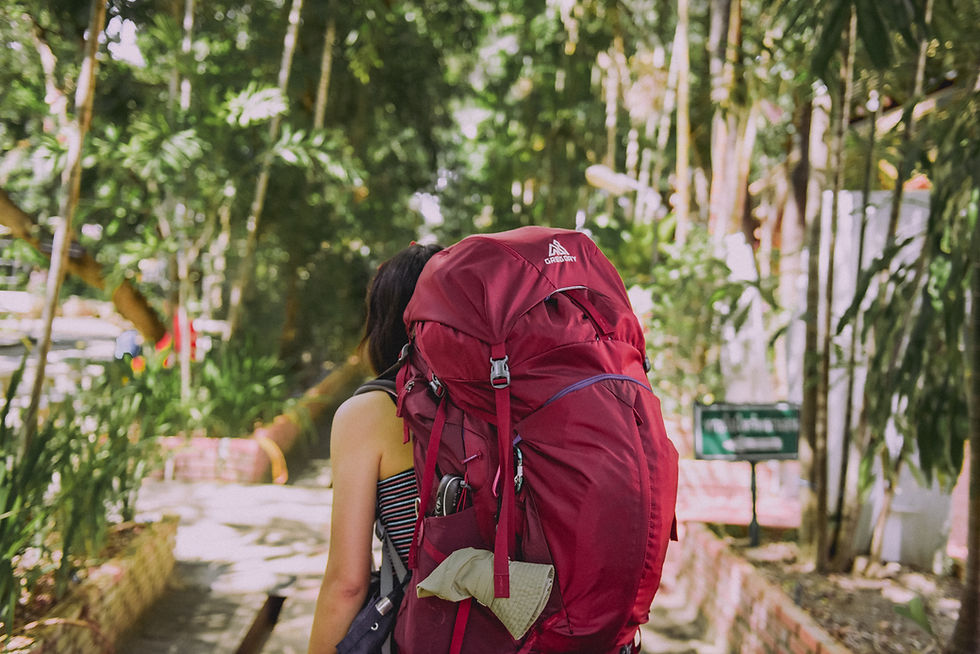 Woman carrying a big red backpack on her back while traveling