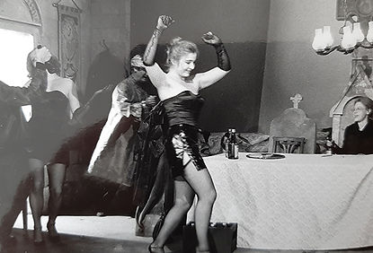 Eine Frau in knappem Gewand schreitet durch eine Festszene