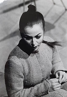 Eine Frau im Mantel blickt zur Seite