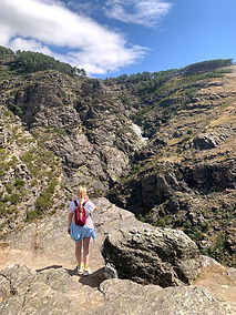 Mary standing among rugged rocks in a mountain valley