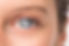 Close-up of a person's blue eye, showing details of the iris and eyebrow. The skin is light, with a natural and neutral mood.