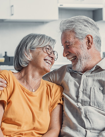 happy-mature-husband-wife-sit-rest-couch-home-hugging-cuddling-show-care-affection-smiling