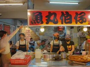 People at a street food stall at Raohe night market in Taiwan