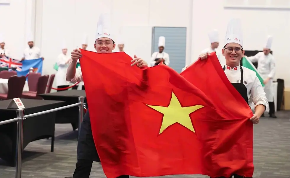 Chefs Le Dac Minh Quan (L) and Trinh Tuan Dung hold the Vietnamese flag at the Global Chefs Challenge 2026's final