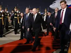 Russia's President Vladimir Putin is welcomed by Chinese Foreign Minister Wang Yi upon his arrival at Beijing Capital Airport in Beijing late on May 19, 2026