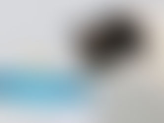 Aquarell-Illustration einer schwarz-weißen Katze, die aus einem blau-weißen Trinkbrunnen Wasser trinkt.