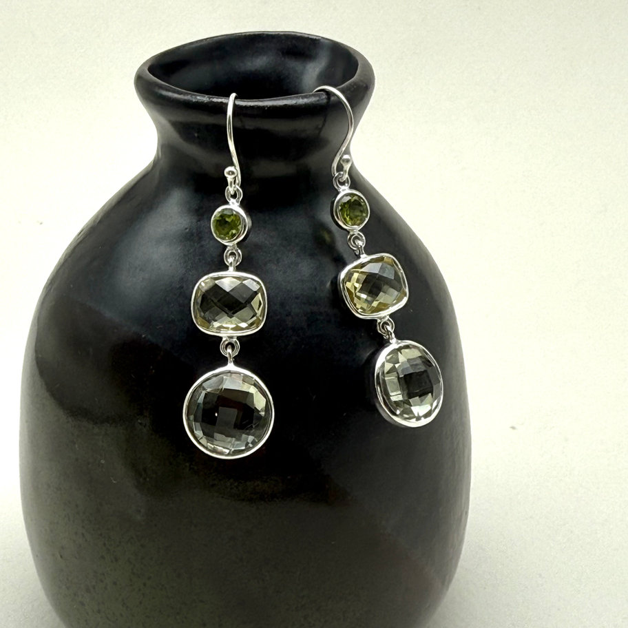 Peridot, Lemon Quartz and Green Amethyst Earrings displayed on a dark ceramic vase, showing faceted gemstone drops.