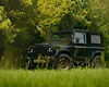 Black Land Rover Defender parked in a grassy field