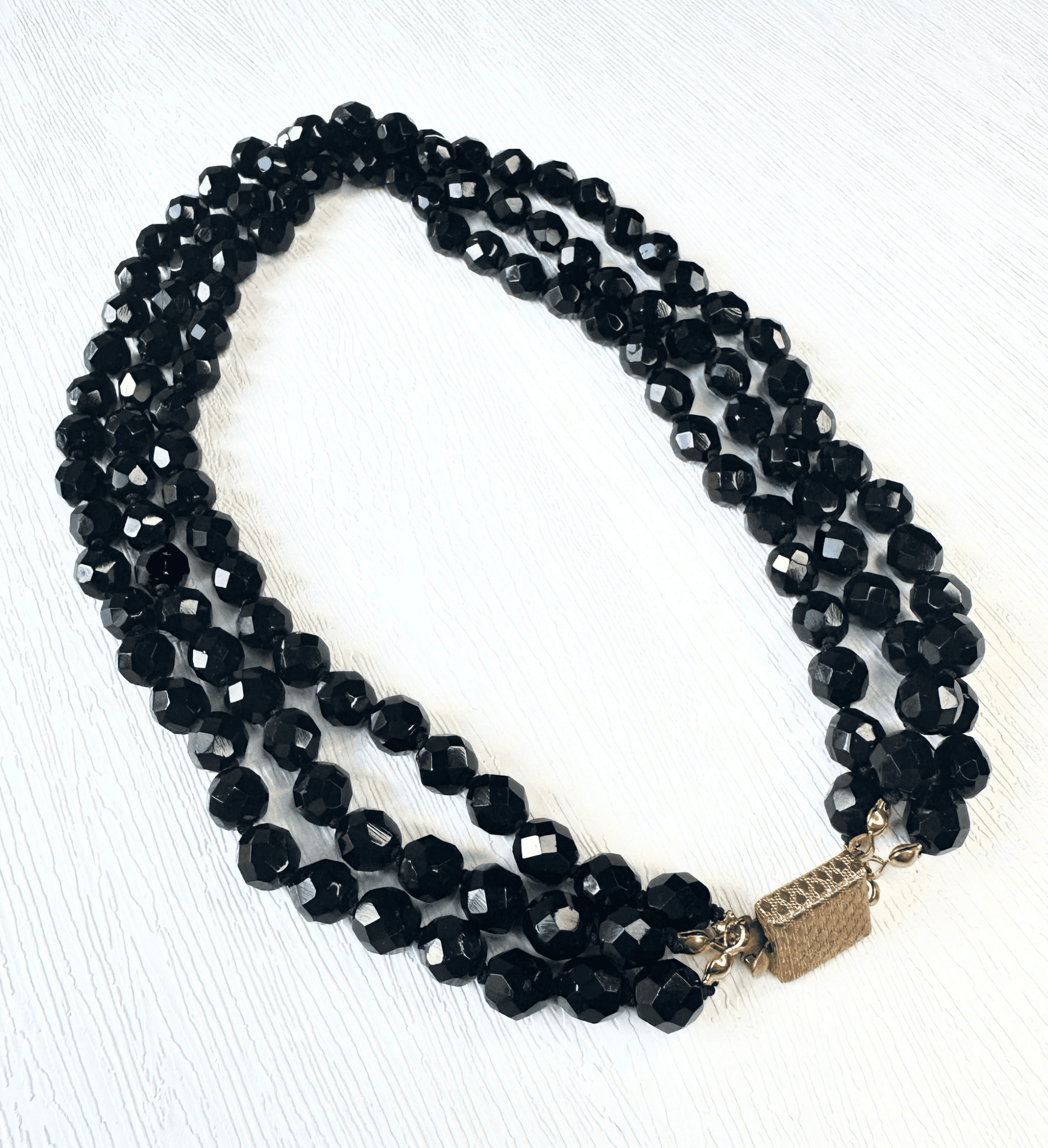 Vintage triple strand black faceted glass bead necklace with gold tone box clasp