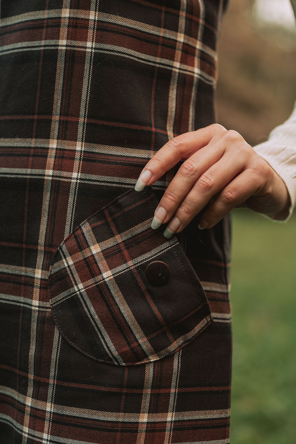 Close-up of a brown checked garment with carefully matched pocket detail