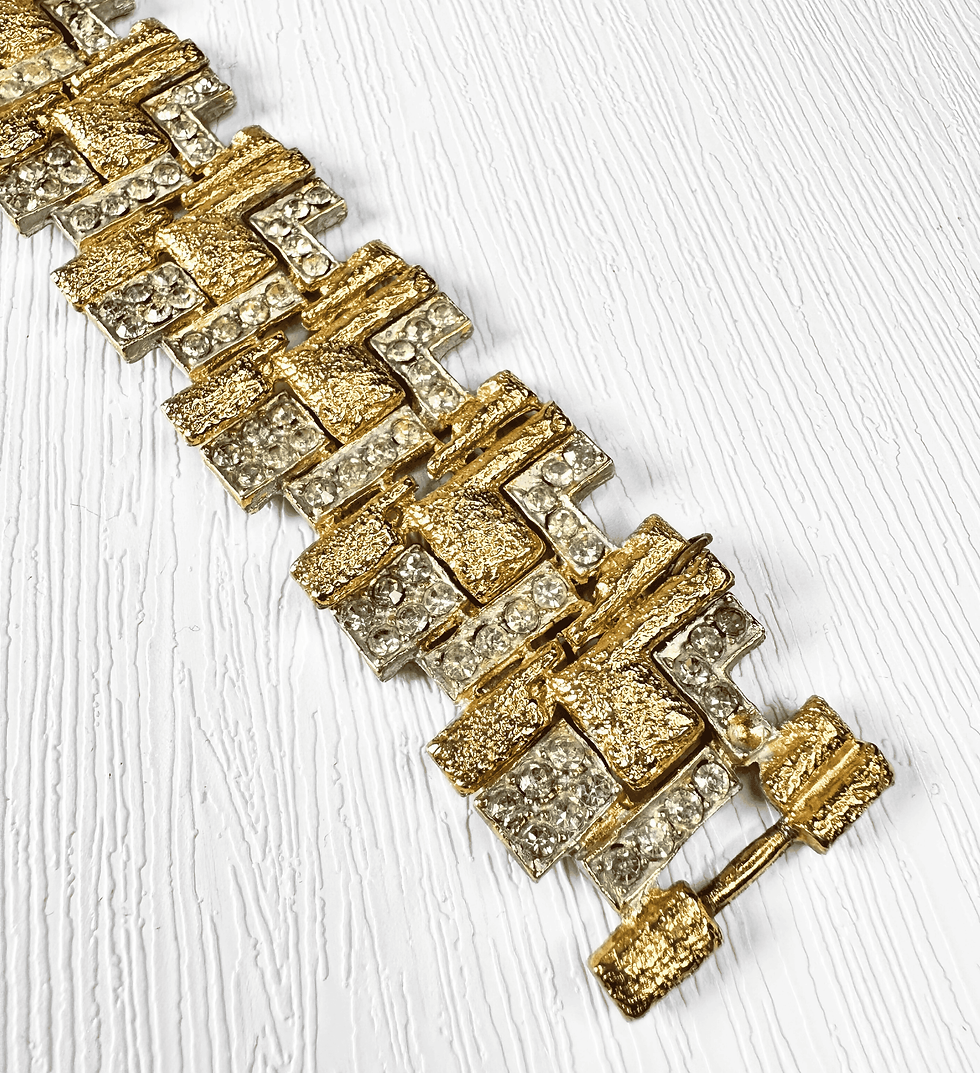 Thumbnail: Detailed angled view of textured goldtone and rhinestone design on vintage 1960s bracelet