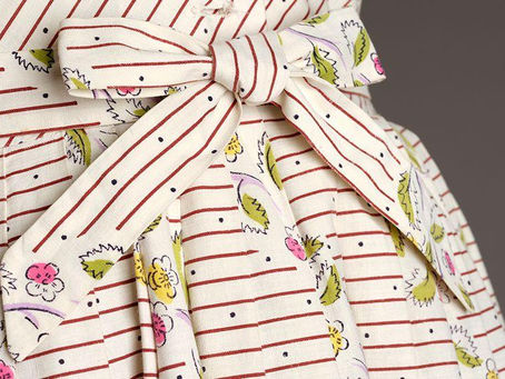 Close up shot of a vintage Horrockses dress from the 1950s. Cream cotton with little ditsy flowers and brown horizontal striping