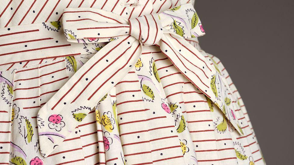 Close up shot of a vintage Horrockses dress from the 1950s. Cream cotton with little ditsy flowers and brown horizontal striping