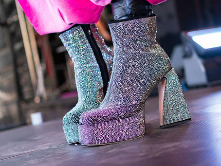 Sparkling platform boots worn with bright pink flares illustrating the history of platform shoes