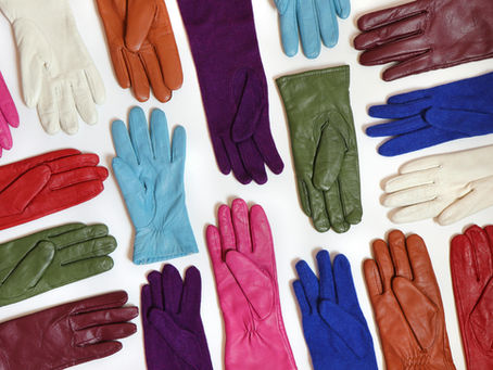 Colourful vintage gloves arranged on a white background, featuring shades of pink, blue, green, red, and white, creating a vibrant pattern.