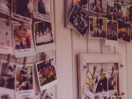 Collection of instant photographs displayed on a wall, illustrating nostalgia and the memories that inspire the return of retro trends.