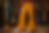 Person in mustard yellow bell-bottoms and beige platform shoes stands in a vintage clothing store with patterned dresses in the background.