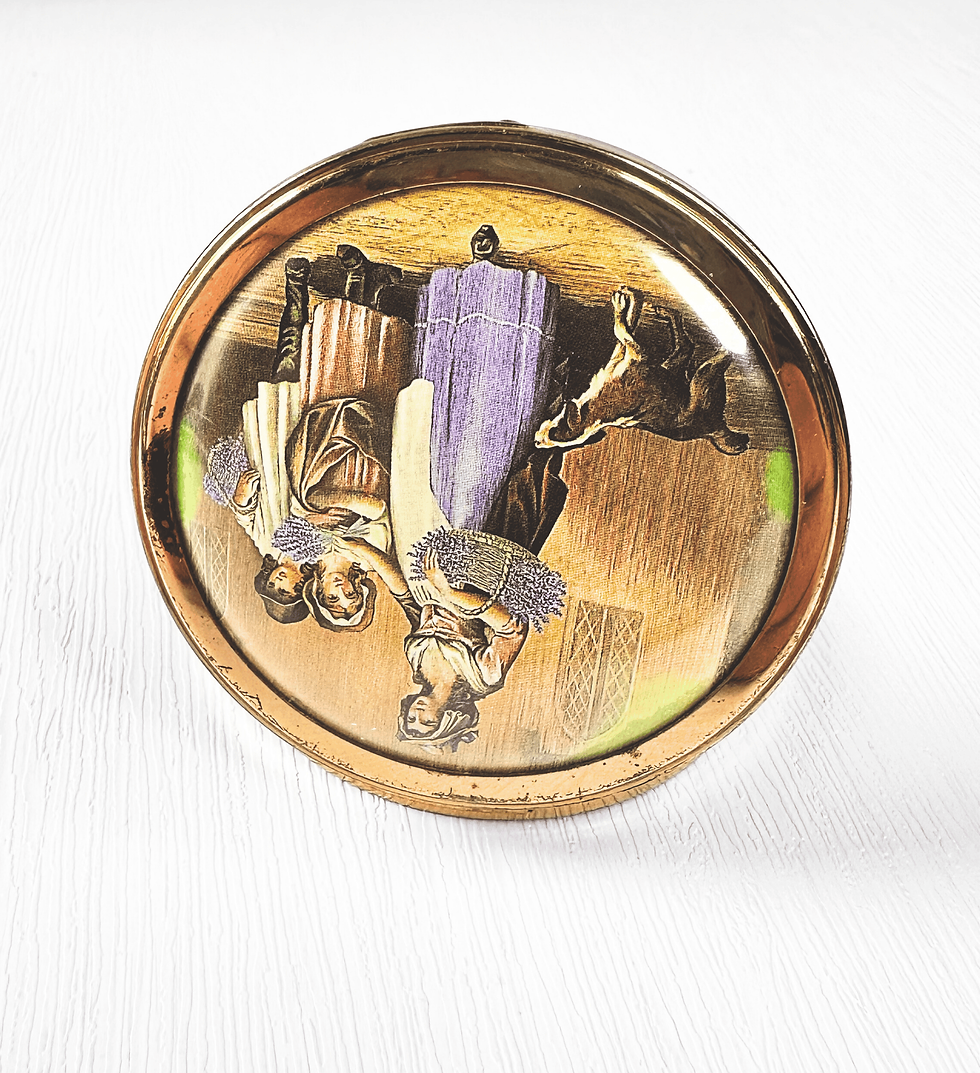 Thumbnail: Angled view of vintage Max Factor compact with illustrated pastoral lid design in goldtone finish.