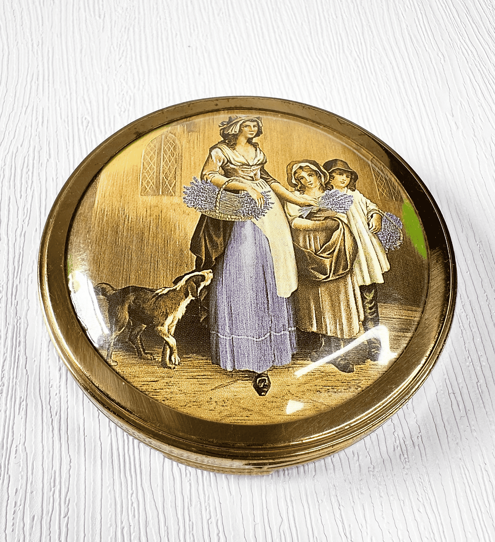 1950s Vintage Max Factor compact with goldtone case and pastoral scene of women with lavender and a dog on the lid.