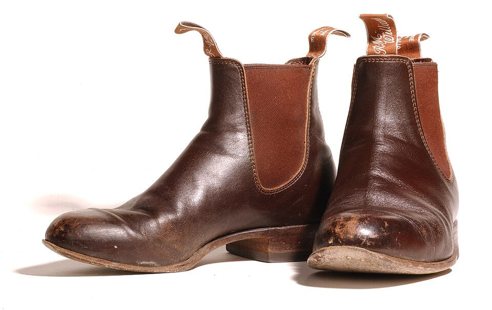 Well-worn brown leather Chelsea boots with elastic side panels and pull tabs showing the traditional slip-on design.