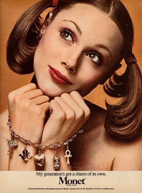 1974 Monet jewellery advert showing a woman wearing a gold charm bracelet with novelty charms.