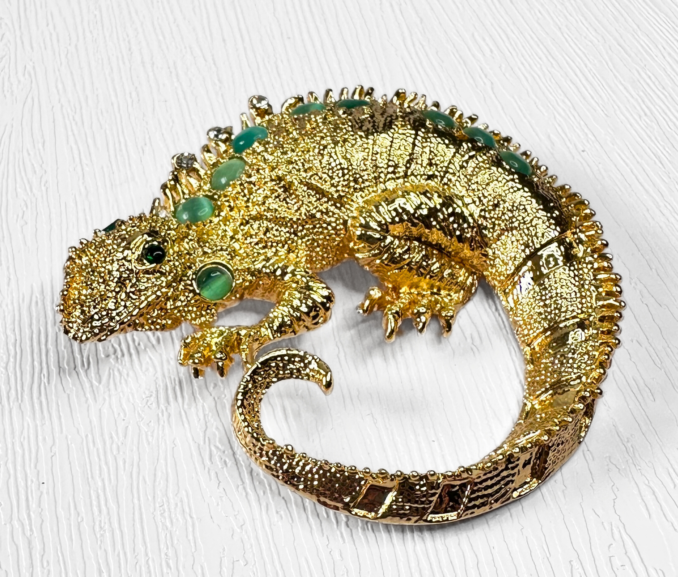 Gold-tone chameleon novelty brooch with green stones and textured detail