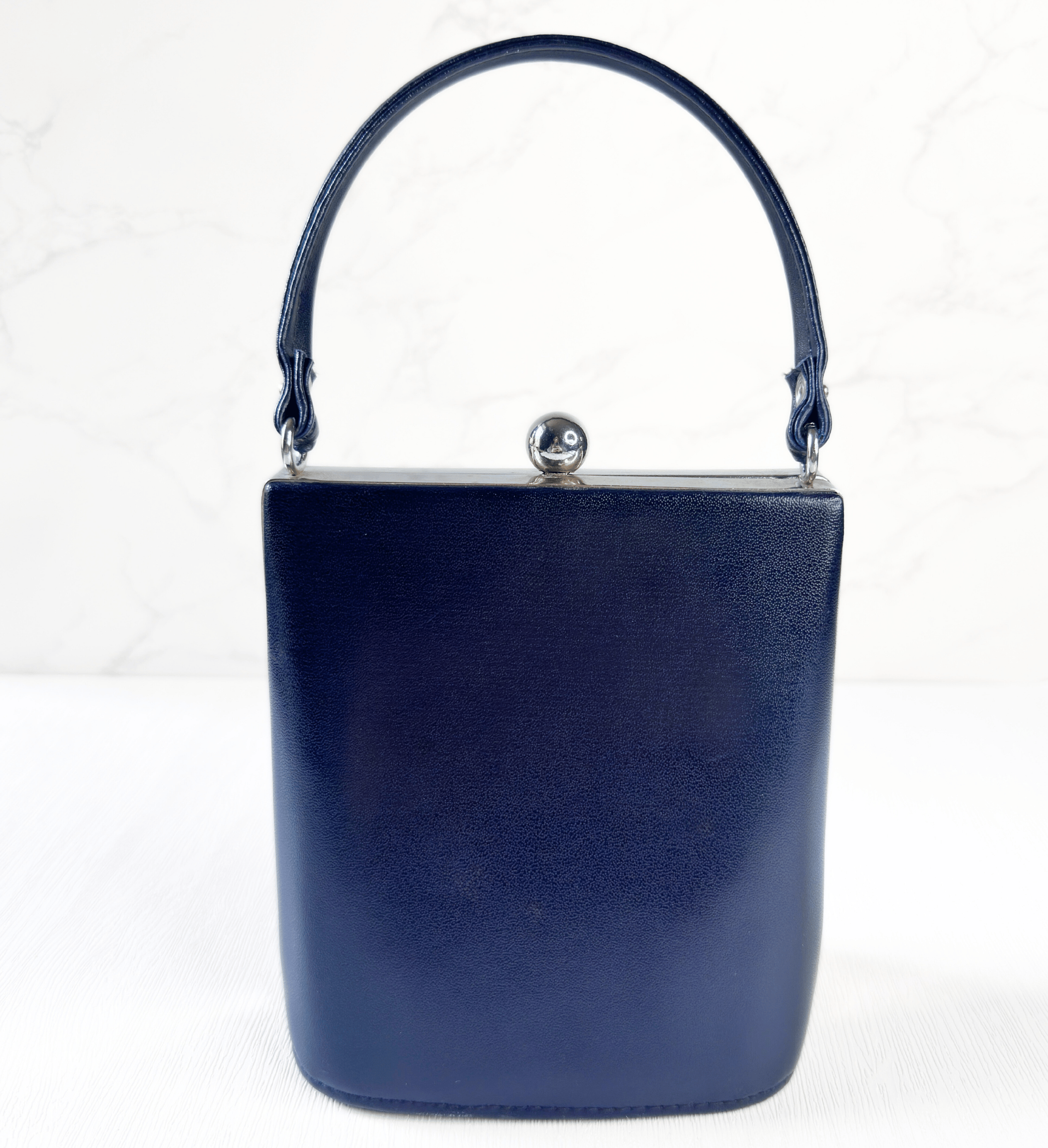 1960s vintage navy structured evening bag front view with classic clasp and sleek silhouette