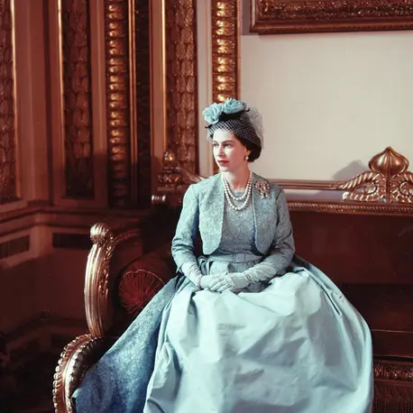 Portrait photograph of Queen Elizabeth II in a stunning pale blue gown and matching jacket, designed by Norman Hartnell.