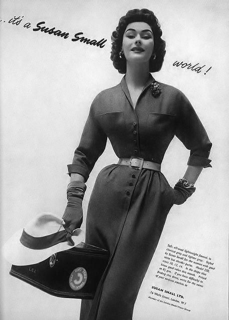 Vintage black-and-white fashion ad of a smiling woman in a belted dress holding a hat and handbag, with text It's a Susan Small world!
