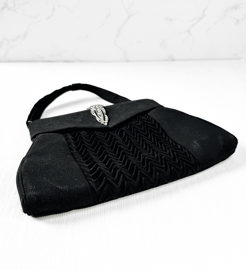 Side angle of 1950s vintage black fabric evening bag with sparkling marcasite clasp
