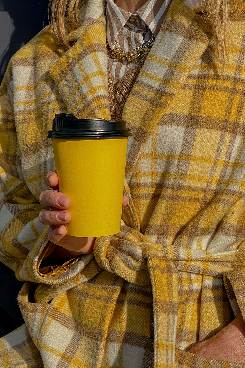 Close-up of a mustard yellow checked wool coat