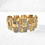 Thumbnail: Front angled view of vintage 1960s chunky goldtone geometric bracelet with rhinestones