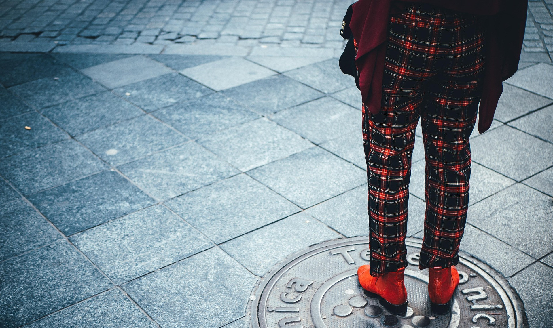 Person wearing red and black tartan trousers with red boots