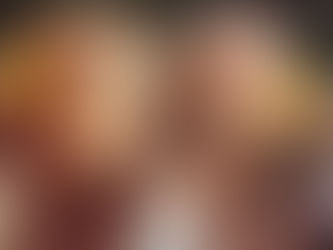 Two women with long hair adorned with yellow flowers. One applies henna while the other smells a flower. Bohemian vibe, nature background.