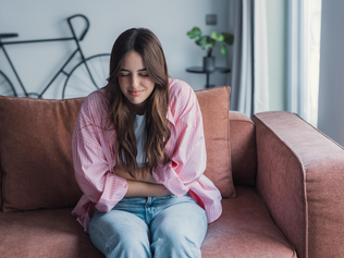 Mujer con gesto de dolor sujetándose el abdomen durante la menstruación.