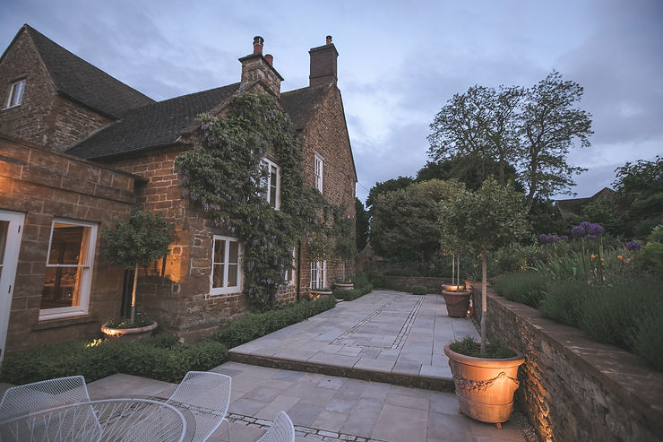 An outdoor patio area at a country home, utilising these six garden lighting tips.