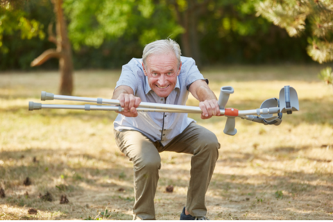 Elderly man performing a squat with crutches in his hand benefiting from Falls Prevention Programme in Llandysul to improve balance and leg strength.