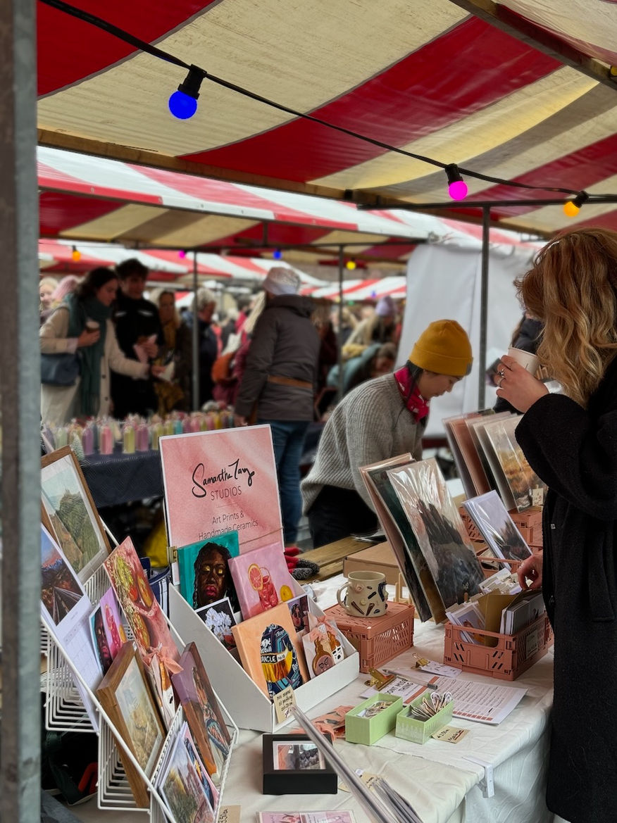 Samantha at the swan market in Utrecht with art prints, calendars and framed prints