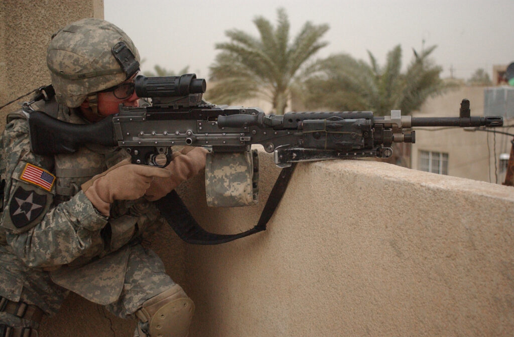 U.S. Army Spc. Kevin Kane, from Bravo Company, 1st Battalion, 23rd Infantry Regiment, 2nd Infantry Division, pulls security on top of a roof during a surveillance of neighborhoods in Baghdad, Iraq, Feb. 6, 2007. (U.S. Army Photo by Sgt. Tierney Nowland) (Released)