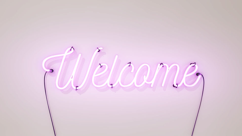 Neon sign that says the word Welcome in bright pink colours, on a white concrete wall back