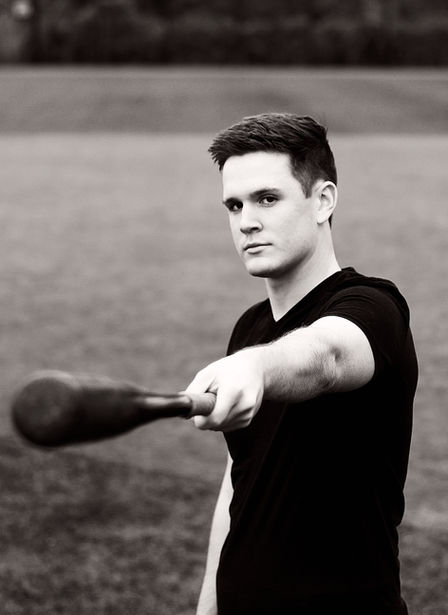 High school senior portrait of a young man in Minneapolis, MN holding out a baseball bat. Photography by Bonni Allen.