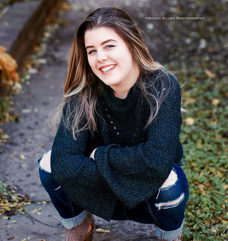 Stylish young woman crouching on the ground in the autumn in Minneapolis, MN, photographed by Bonni Allen.