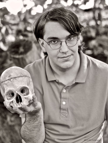 Black and white image of a high school senior holding a skull, reminiscient of Hamlet. Image by Bonni Allen Photography.